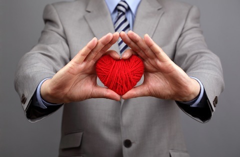 oamenii de afaceri întind o inimă roșie