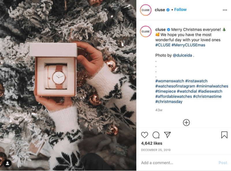 postare instagram de la @cluse care prezintă o imagine a unui model pulover cu fulgi de zăpadă care ține un ceas în fața unui copac înzăpezit de @dulceida cu hashtagurile #cluse și #meryclusemas