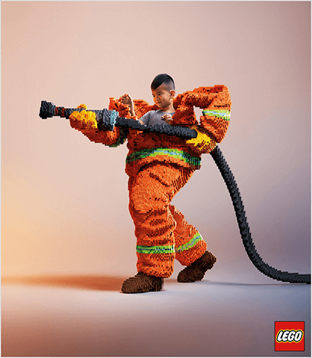Aceasta este o fotografie dintr-un anunț LEGO care arată un tânăr băiat asiatic în interiorul unei uniforme de pompier din LEGO. Uniforma este portocalie cu o dungă verde neon în jurul mansetelor hainei și al pantalonilor. Pompierul stă în picioare cu un picior în spate și ține un furtun de foc, tot din legos. Capul băiatului apare în partea de sus a uniformei, care este mult mai mare decât el și se oprește în jurul umerilor. Fotografia a fost făcută pe un fundal neutru simplu. Logo-ul LEGO apare într-o cutie roșie în dreapta jos. Talia Wolf spune că LEGO este un excelent exemplu de brand care folosește emoția în publicitate.