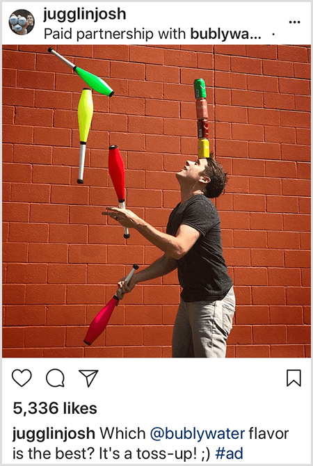 Josh Horton jonglează cu cluburi care se potrivesc cu culorile a patru cutii de apă Bubly stivuite pe cap. Fundalul este un zid de cărămidă roșie. Fotografia este un anunț creat de Josh pentru apă Bubly și postat în fluxul său de Instagram cu descrierea Care aromă de apă Bubly este cea mai bună? Este un aruncat!