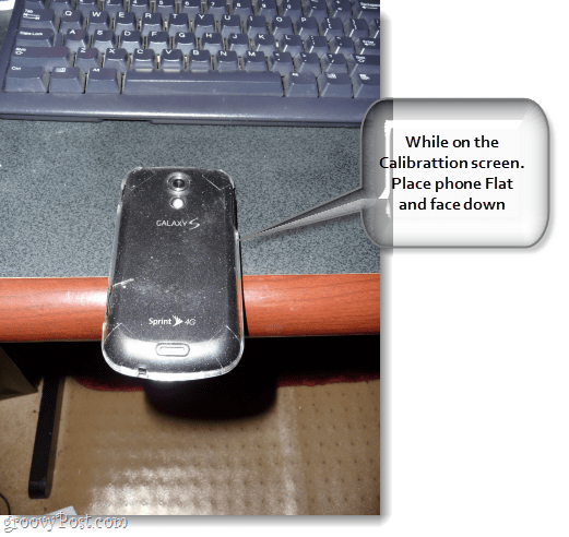 în imagine este o epocă Samsung Galaxy 4g care stă la jumătatea distanței unui birou